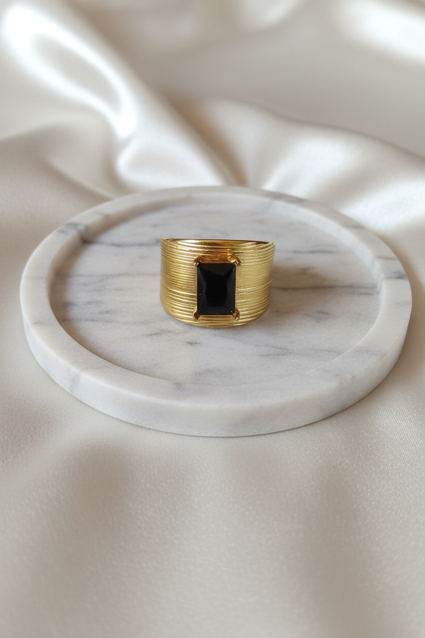 Bague chevalière noire sur plateau marbré
