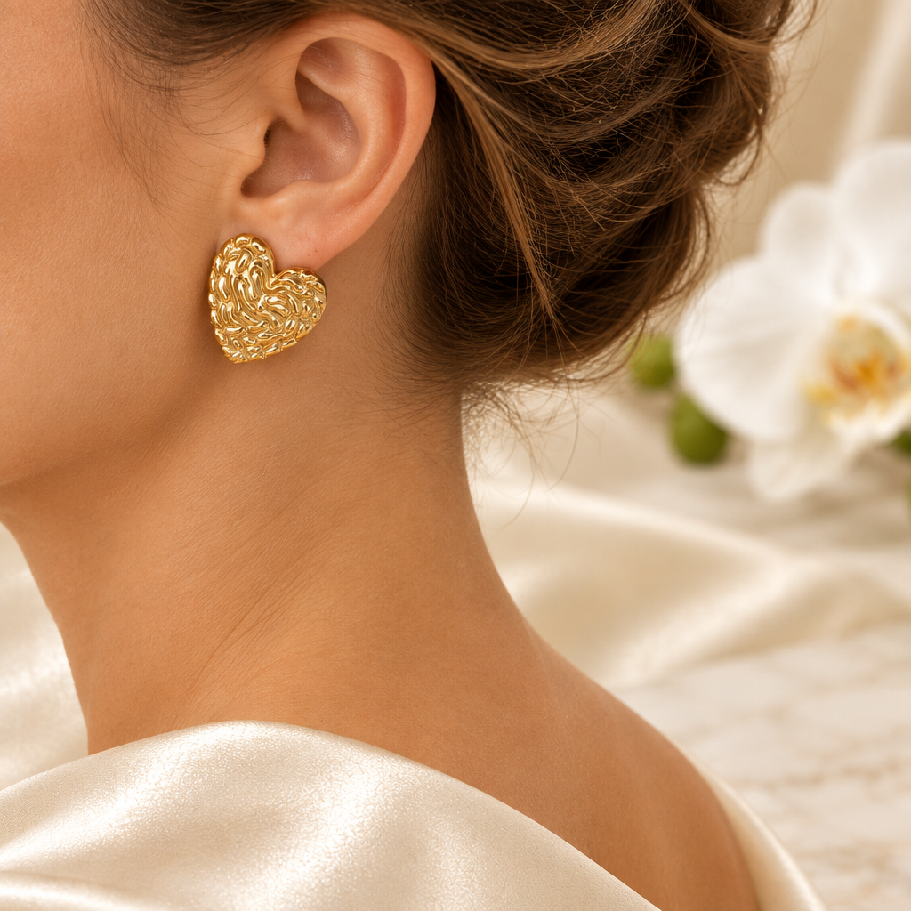 Boucle cœur dorée portée à l’oreille gauche dans le même décor