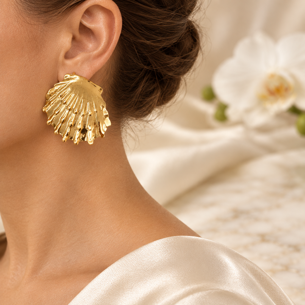 Boucle dorée en éventail portée à l’oreille gauche dans le même décor élégant