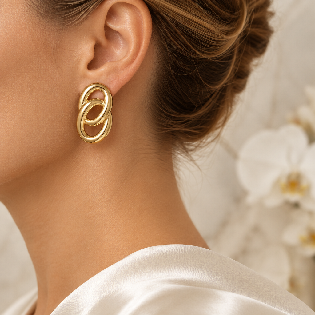 Boucle dorée entrelacée portée à l’oreille gauche dans le même décor élégant