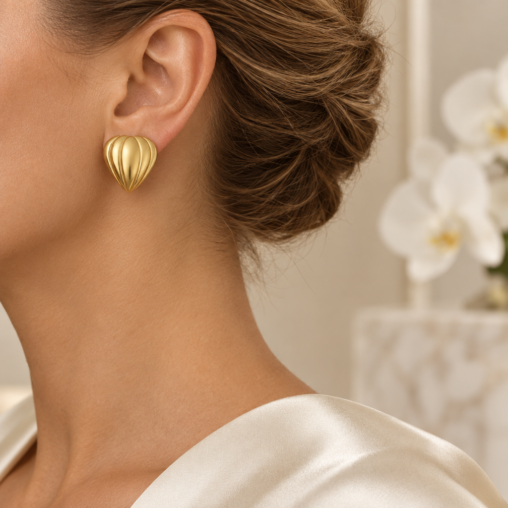 Boucle dorée rainurée portée à l’oreille gauche dans le même décor élégant