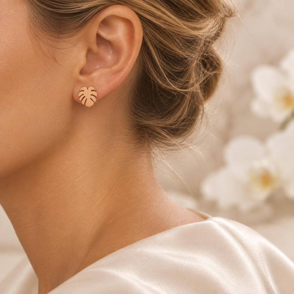 Boucle feuille tropicale portée à l’oreille gauche dans le même décor élégant