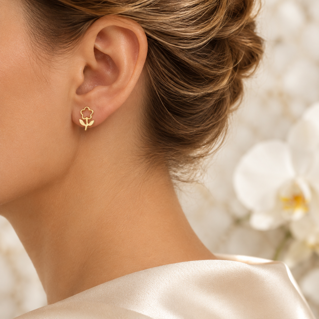 Boucle fleur ajourée dorée portée à l’oreille gauche dans le même décor élégant