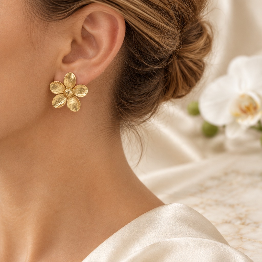 Boucle fleur dorée portée à l’oreille gauche dans le même décor élégant