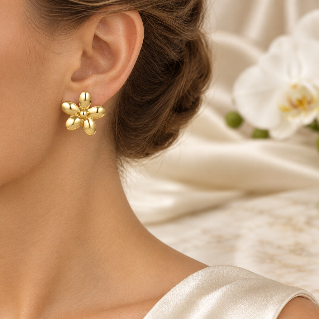 Boucle fleur dorée portée à l’oreille gauche dans le même décor élégant