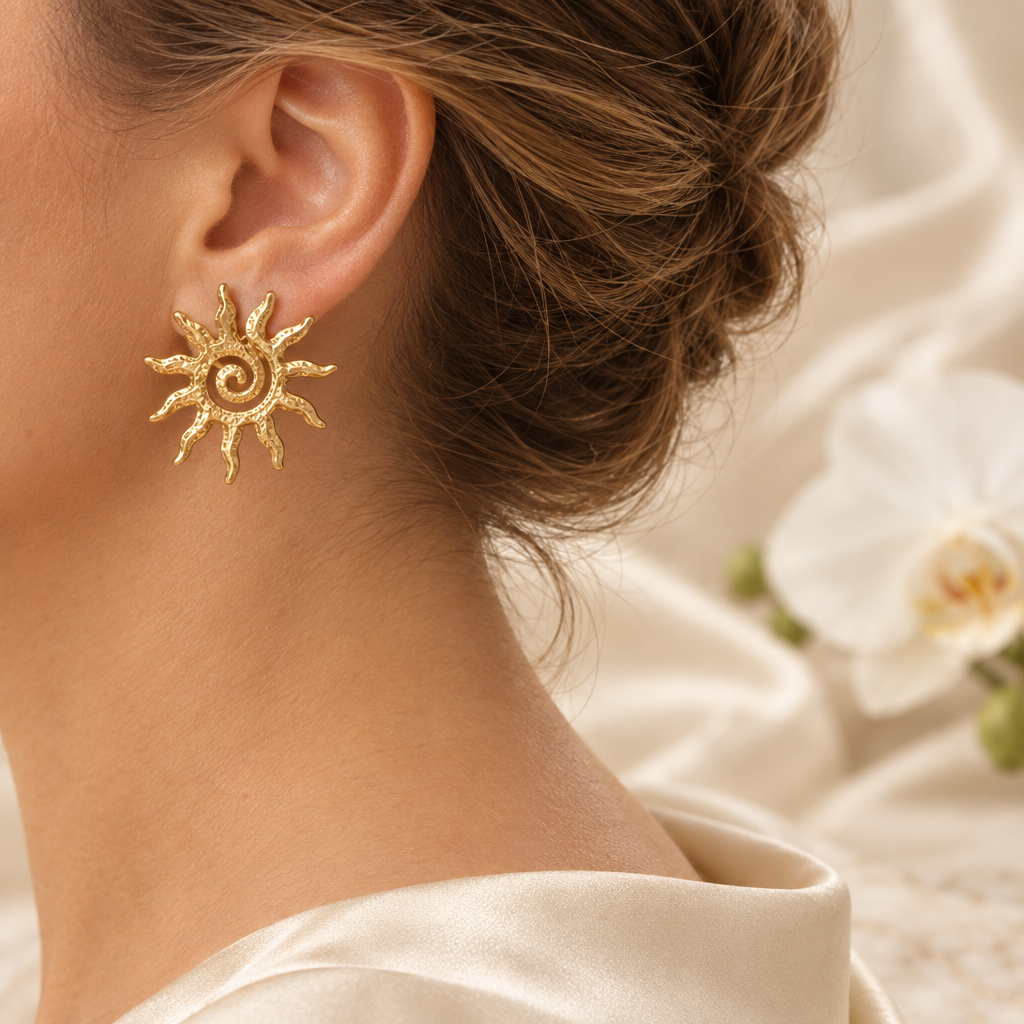 Boucle soleil dorée portée à l’oreille gauche dans le même décor élégant