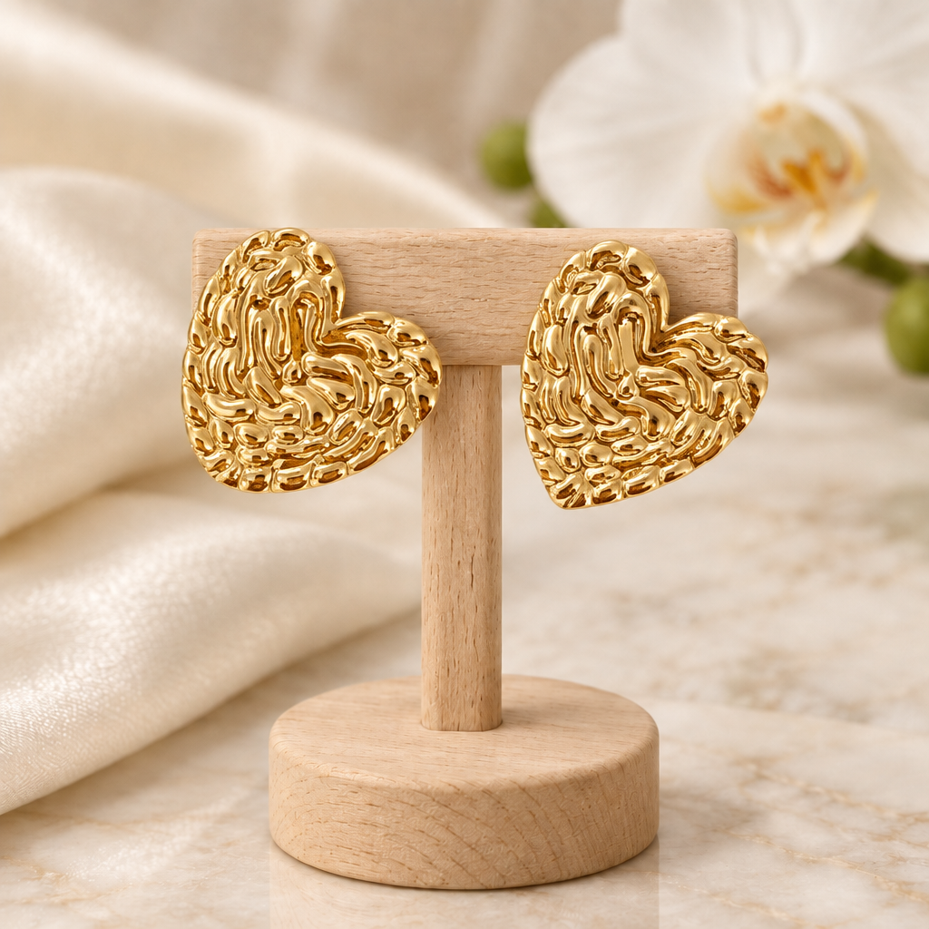 Boucles cœur dorées sur un présentoir en bois dans un décor chic