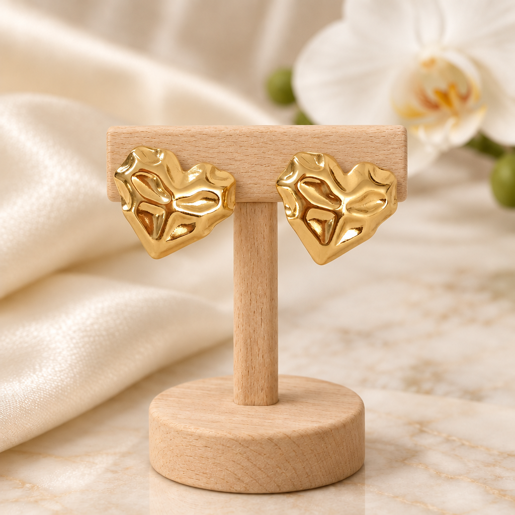 Boucles cœur dorées sur un présentoir en bois dans un décor chic