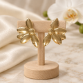 Boucles d’oreilles sur un petit présentoir en bois dans un décor élégant