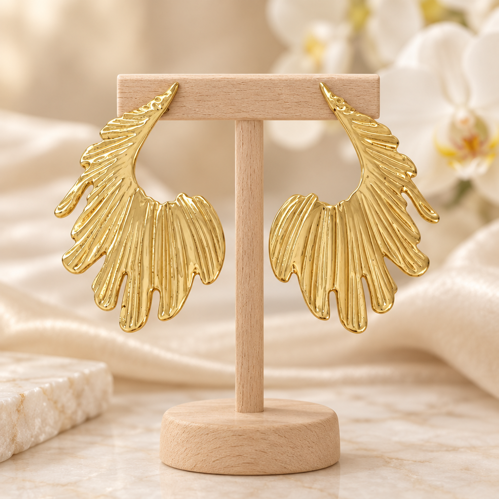 Boucles dorées ajourées sur un présentoir en bois dans un décor chic