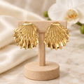 Boucles dorées en éventail sur un présentoir en bois dans un décor chic