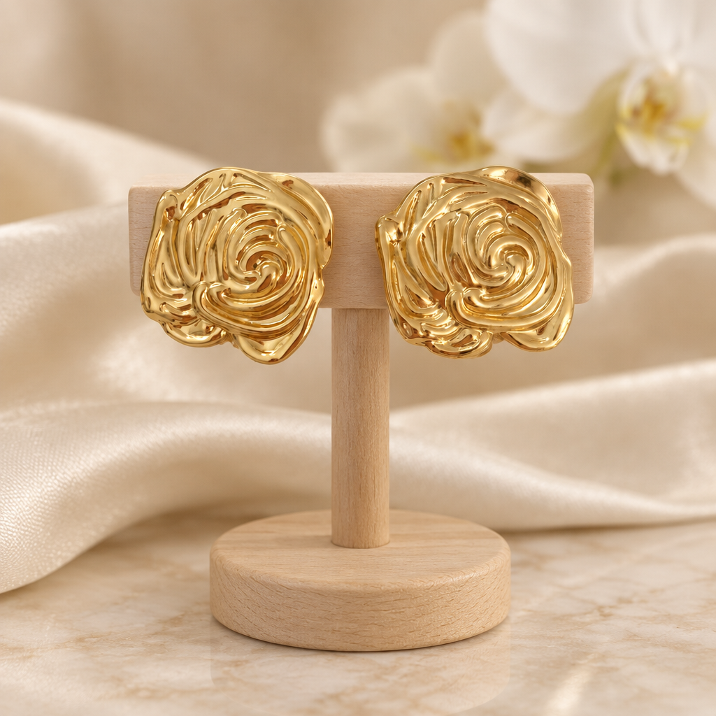 Boucles dorées à relief spiralé sur un présentoir en bois dans un décor chic