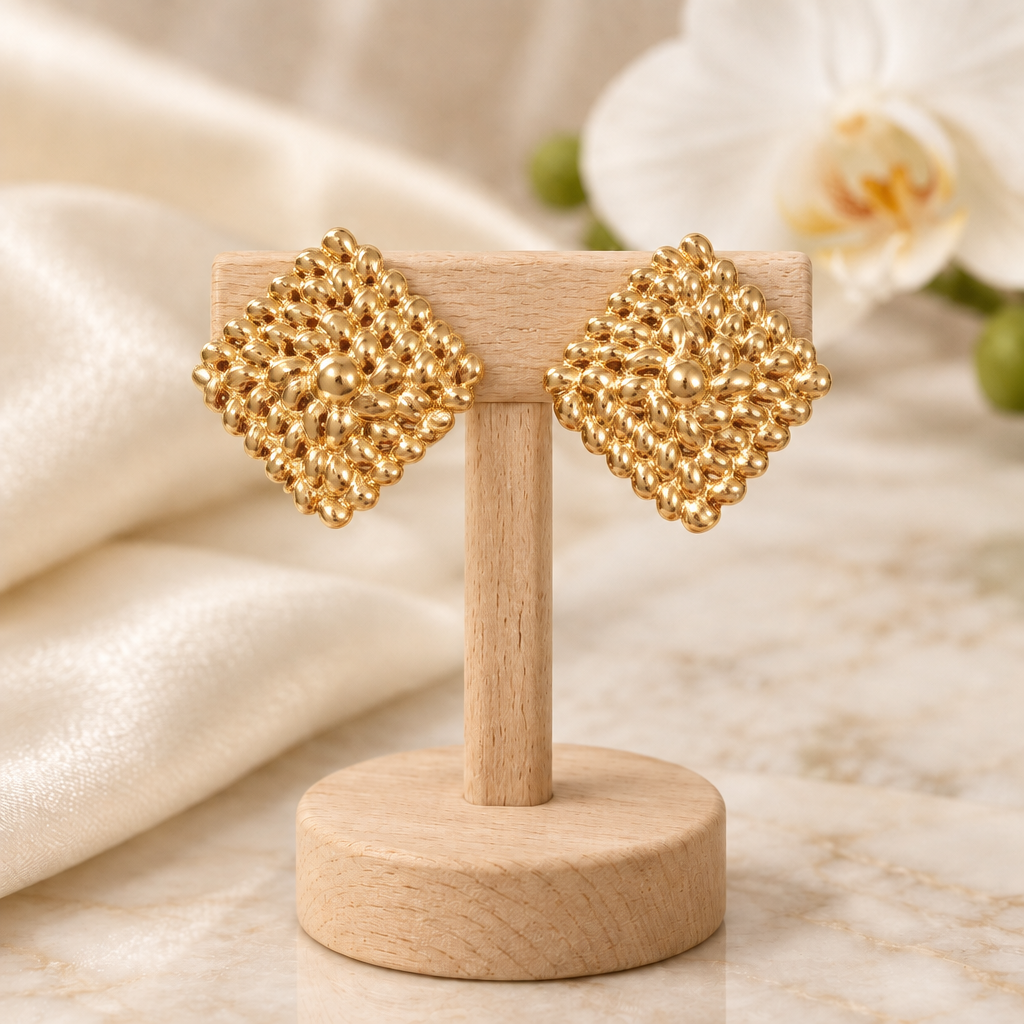 Boucles dorées texturées sur un présentoir en bois dans un décor chic