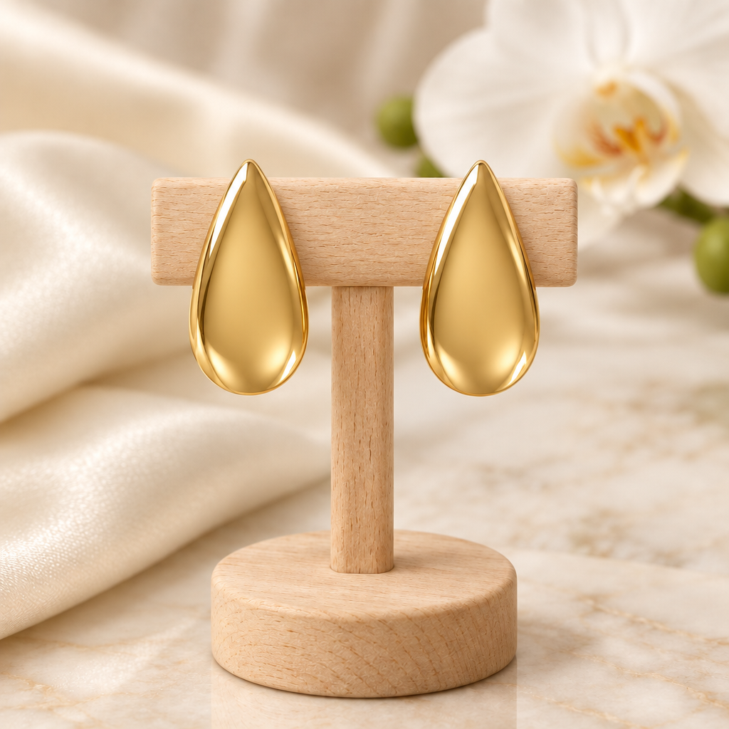 Boucles gouttes dorées sur un présentoir en bois, décor élégant