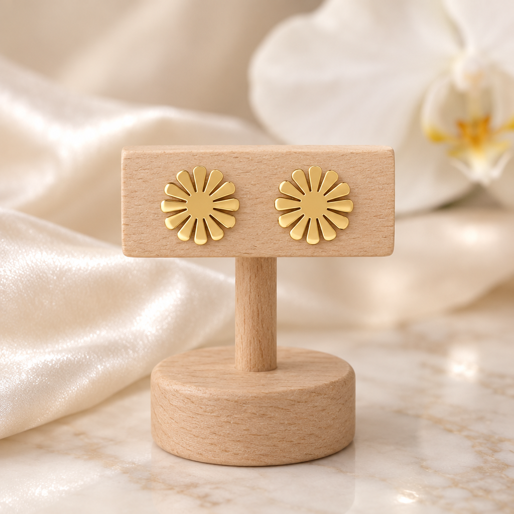 Boucles marguerites dorées sur un présentoir en bois dans un décor chic