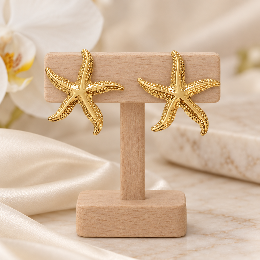 Boucles étoiles de mer dorées sur un présentoir en bois dans un décor chic