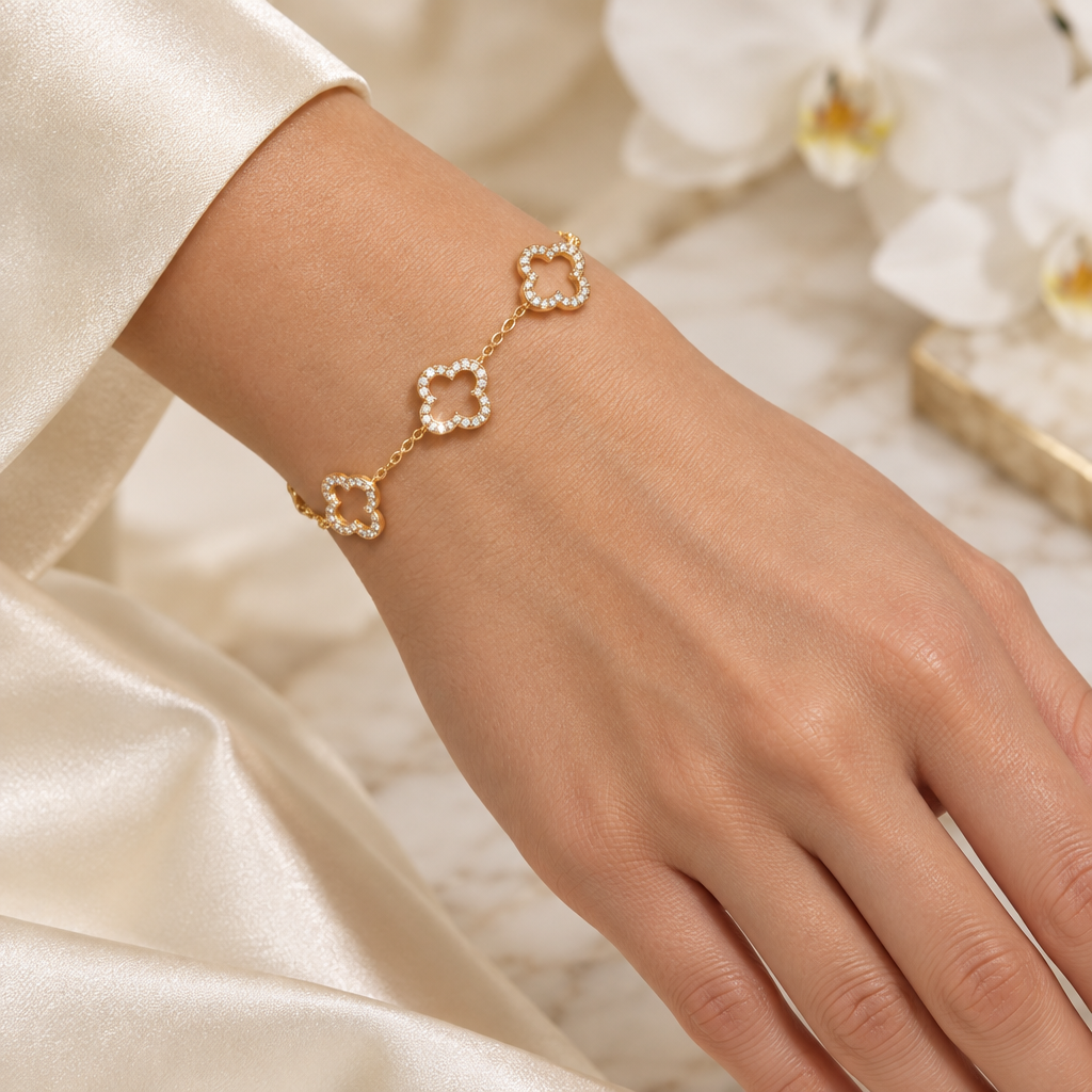 Bracelet doré à strass porté sur un poignet avec une manucure nude