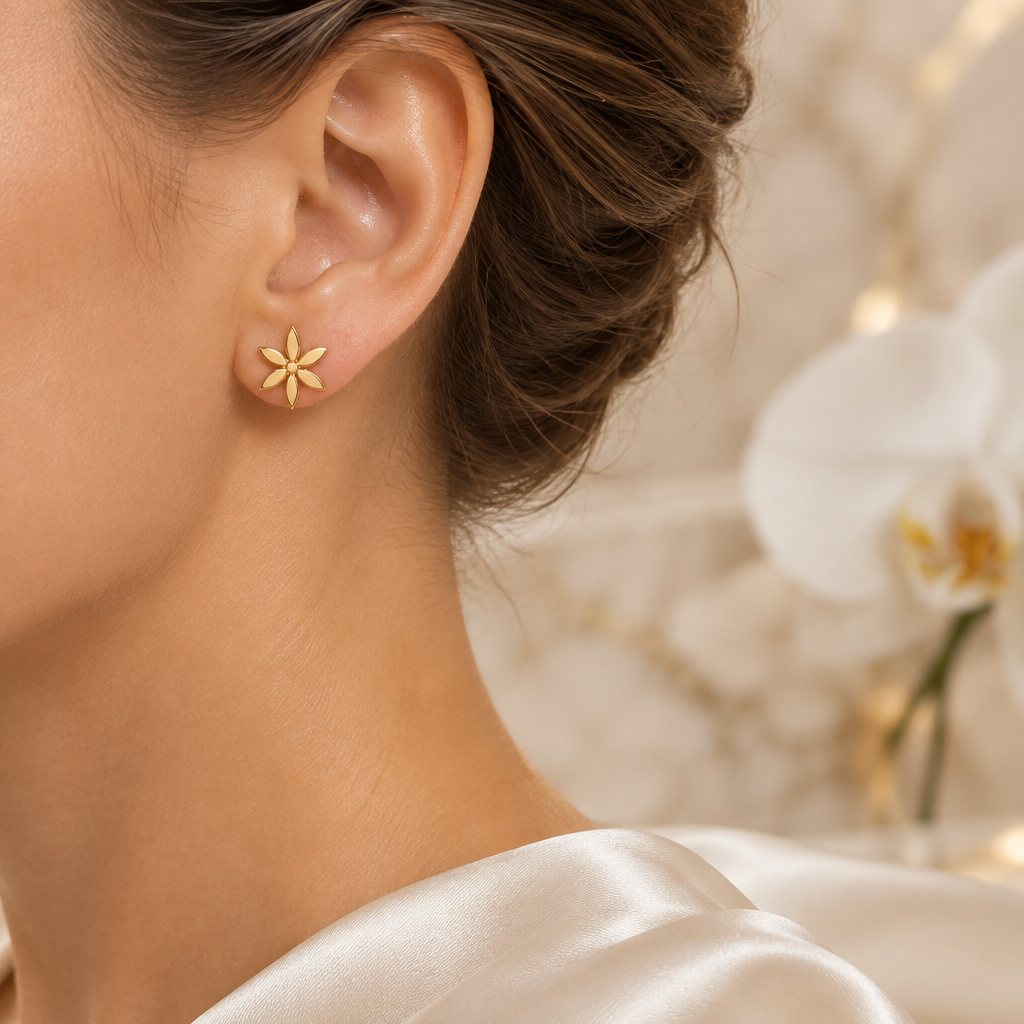 Petite boucle fleur dorée portée à l’oreille gauche dans le même décor élégant
